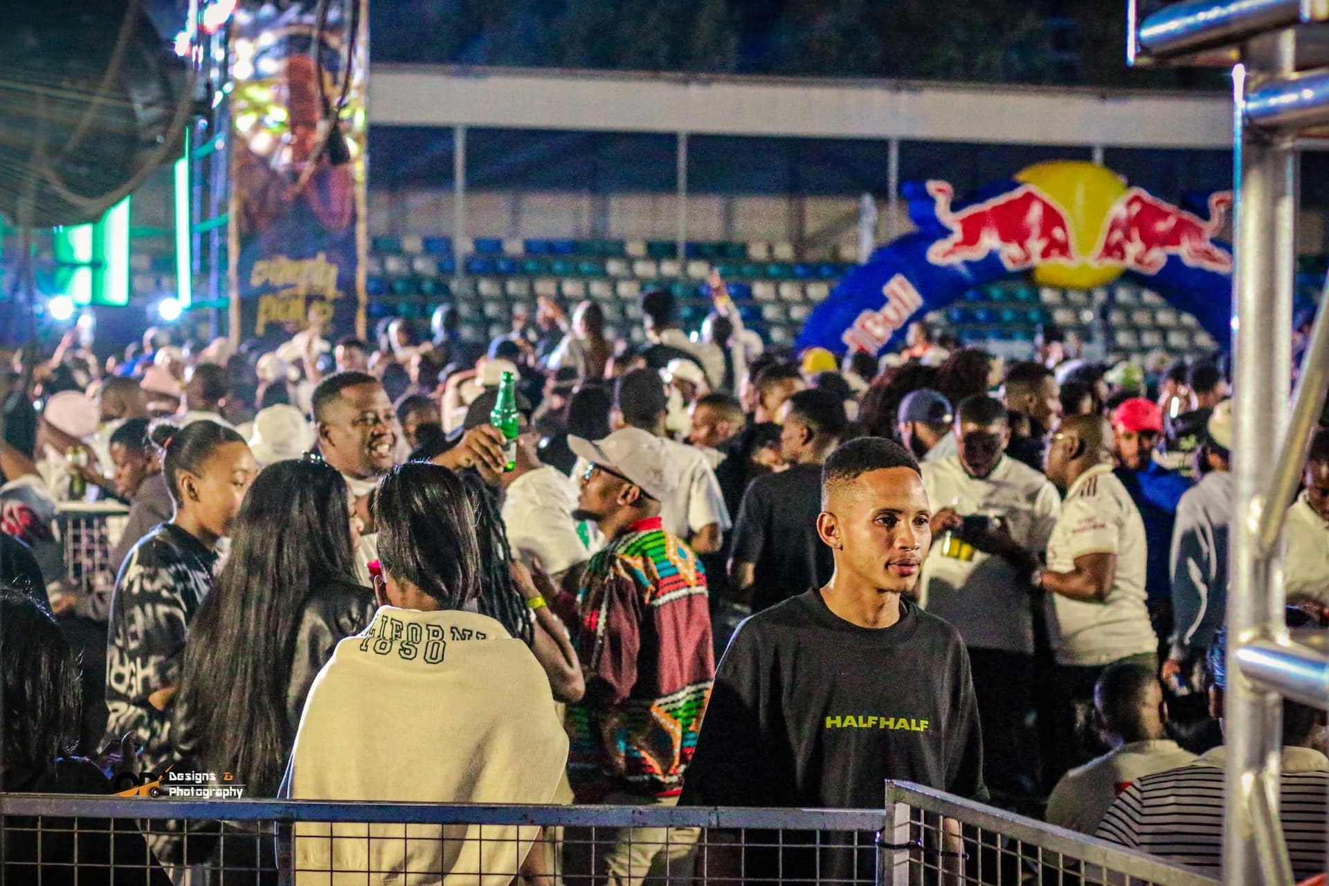 Packed crowd moving between stage barriers at night