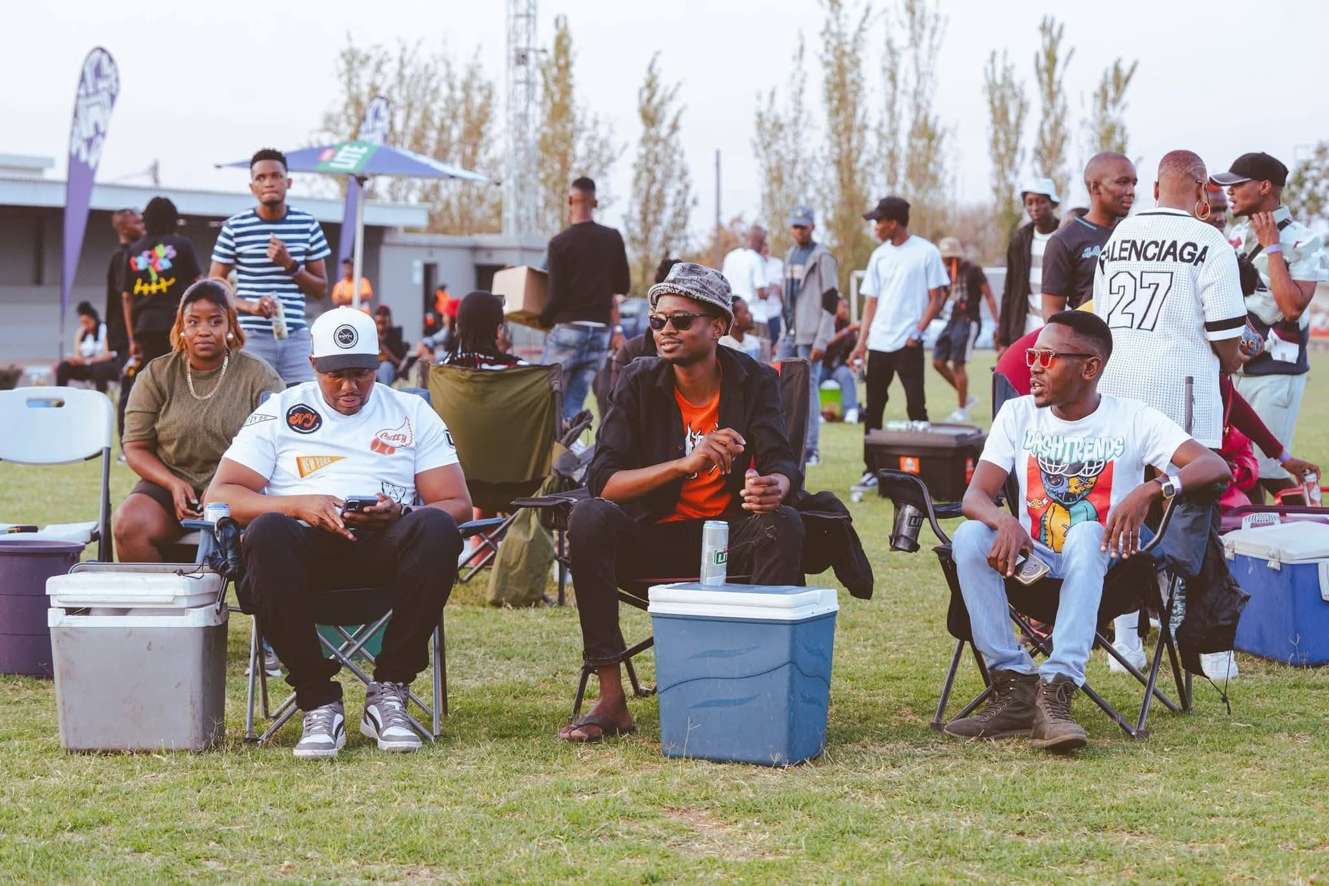 Friends relaxing on camp chairs on the grass at a Simply Piano event