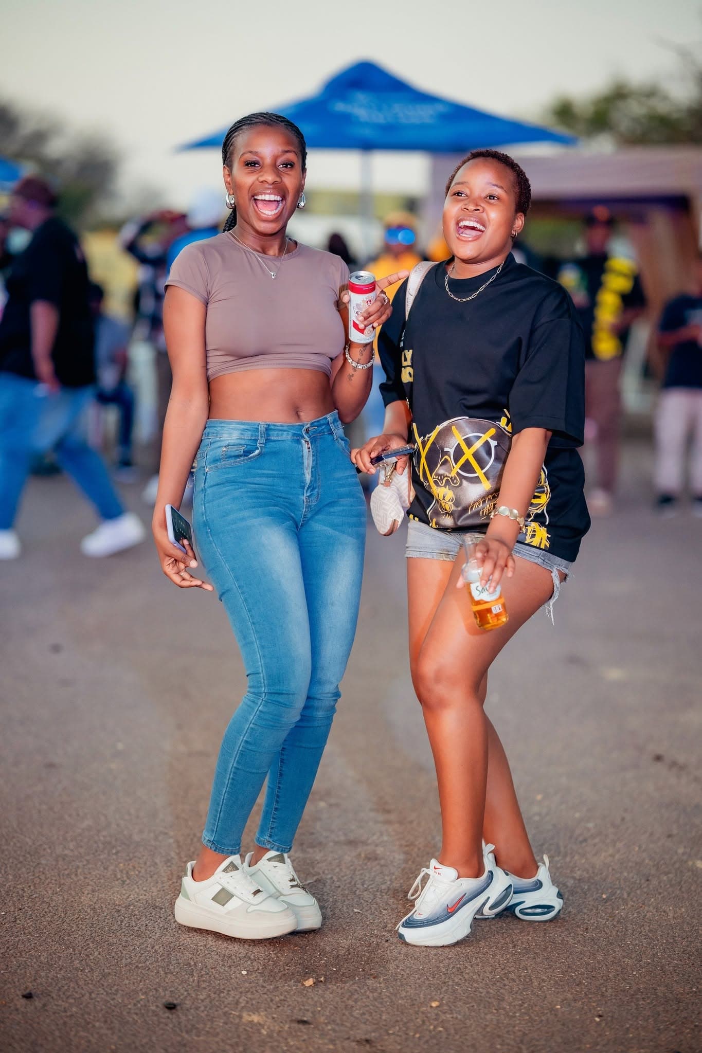 Two friends laughing with drinks at a Simply Piano event