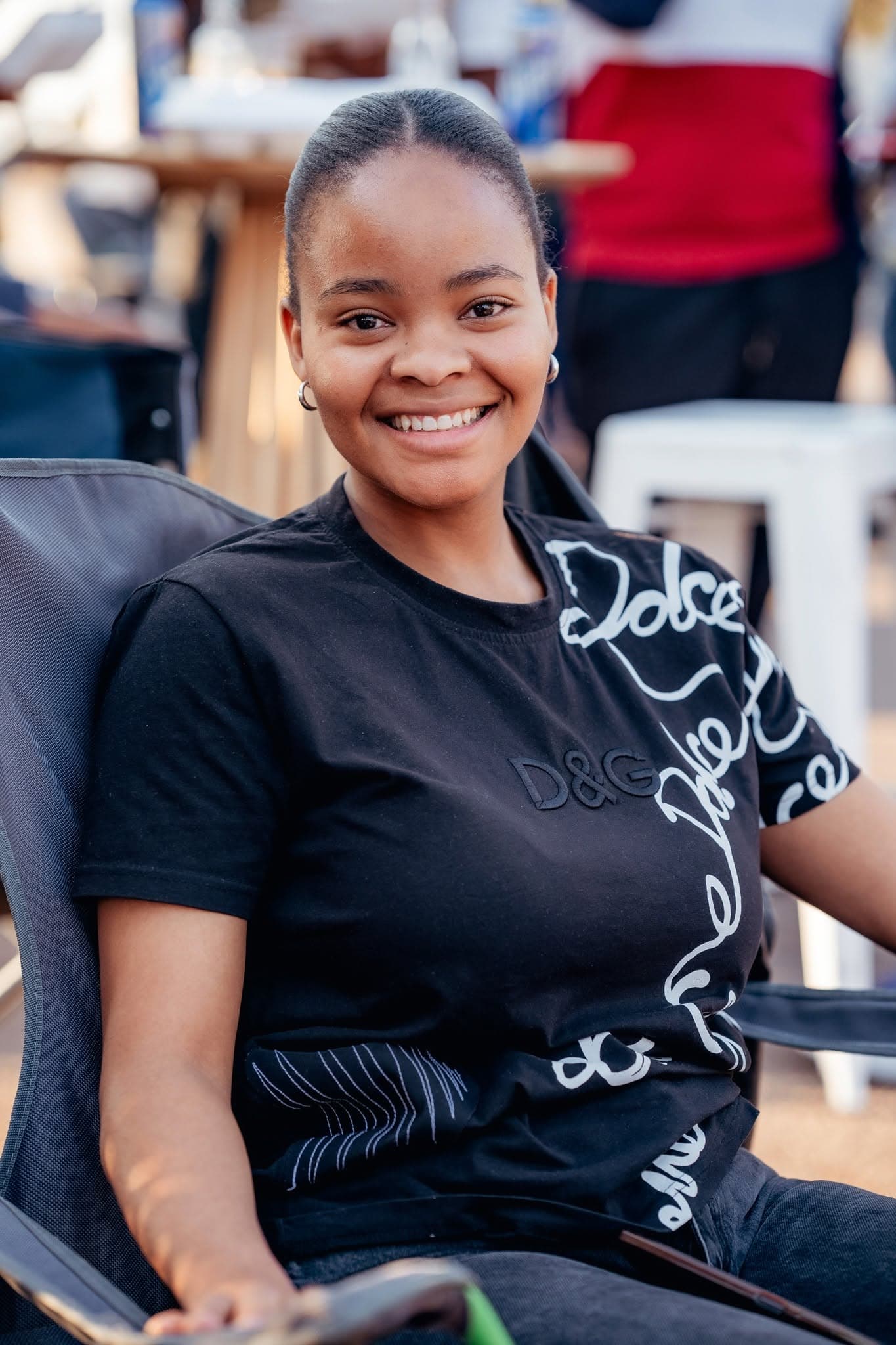 Smiling attendee in a printed black tee at a Simply Piano event