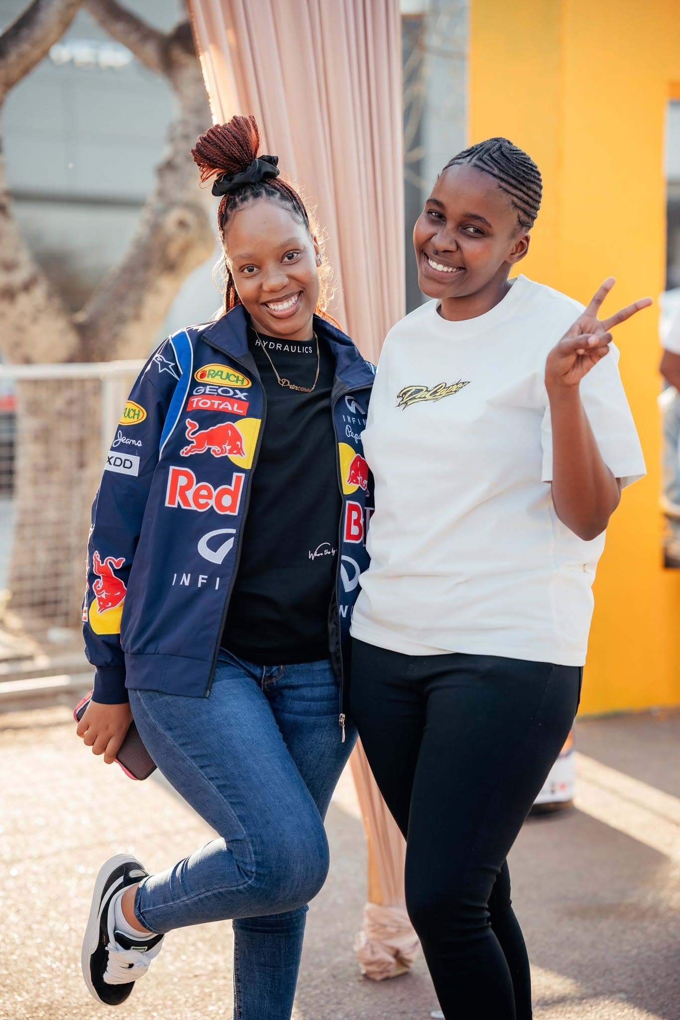Two attendees posing together, one in a racing jacket, at a Simply Piano activation