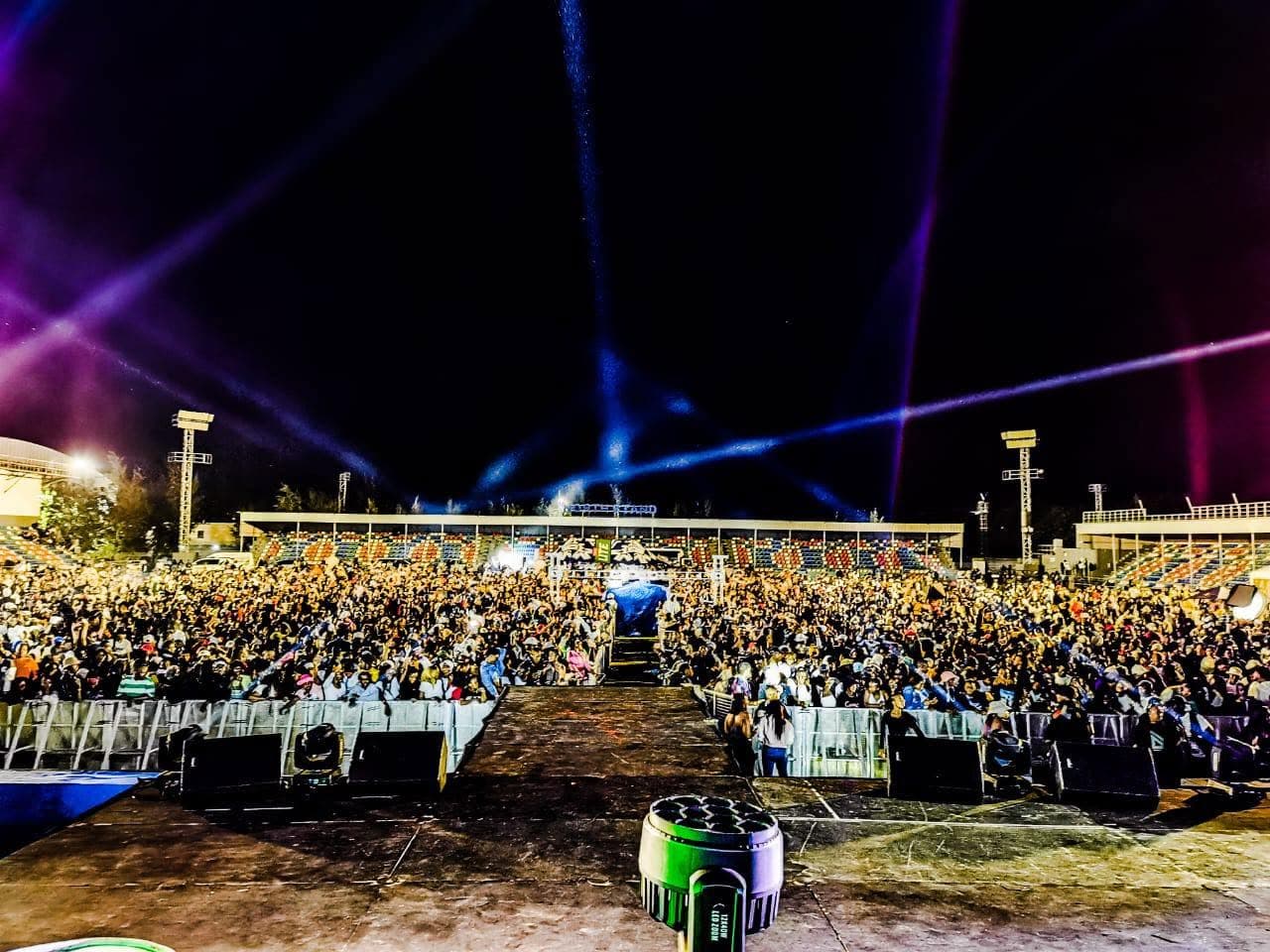 Stadium crowd at night under purple and blue stage lights at a Simply Piano event